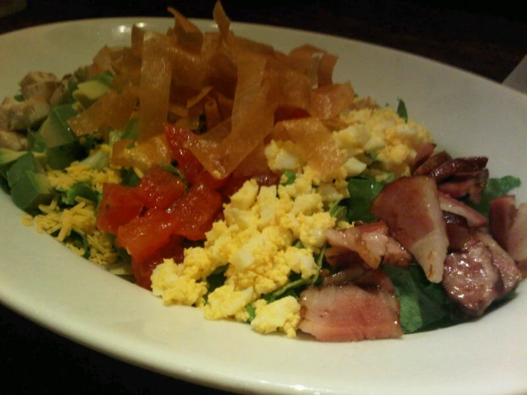 a plate with some bacon some veggies and a bowl