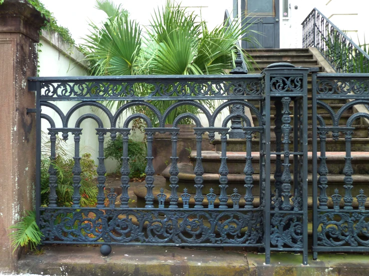 a large wrought iron gate next to some stairs