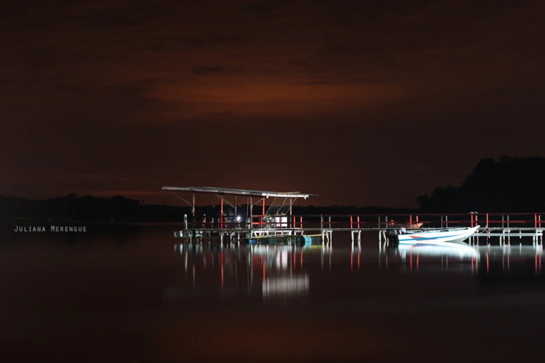 boats docked on water with dark sky in background