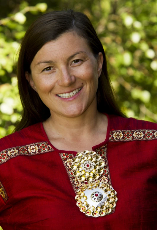 a woman with long hair and red shirt smiles