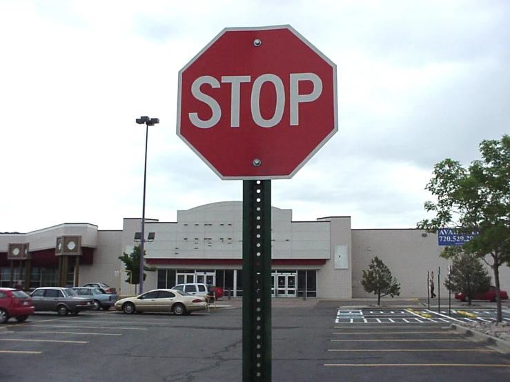 a large stop sign near a parking lot