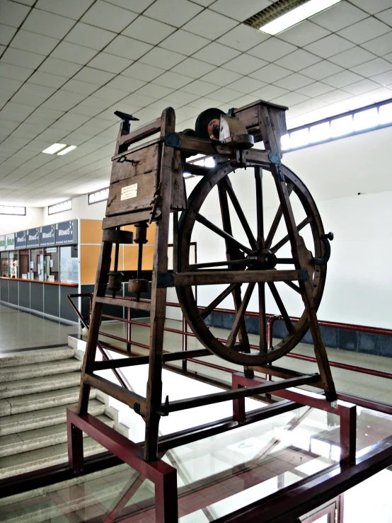 a large spinning wheel on display inside an indoor liry