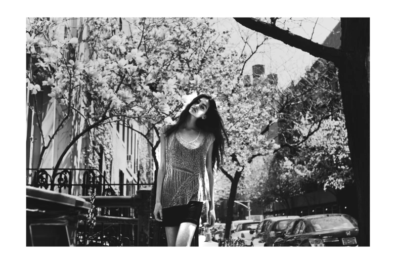 a woman with long hair standing next to some trees