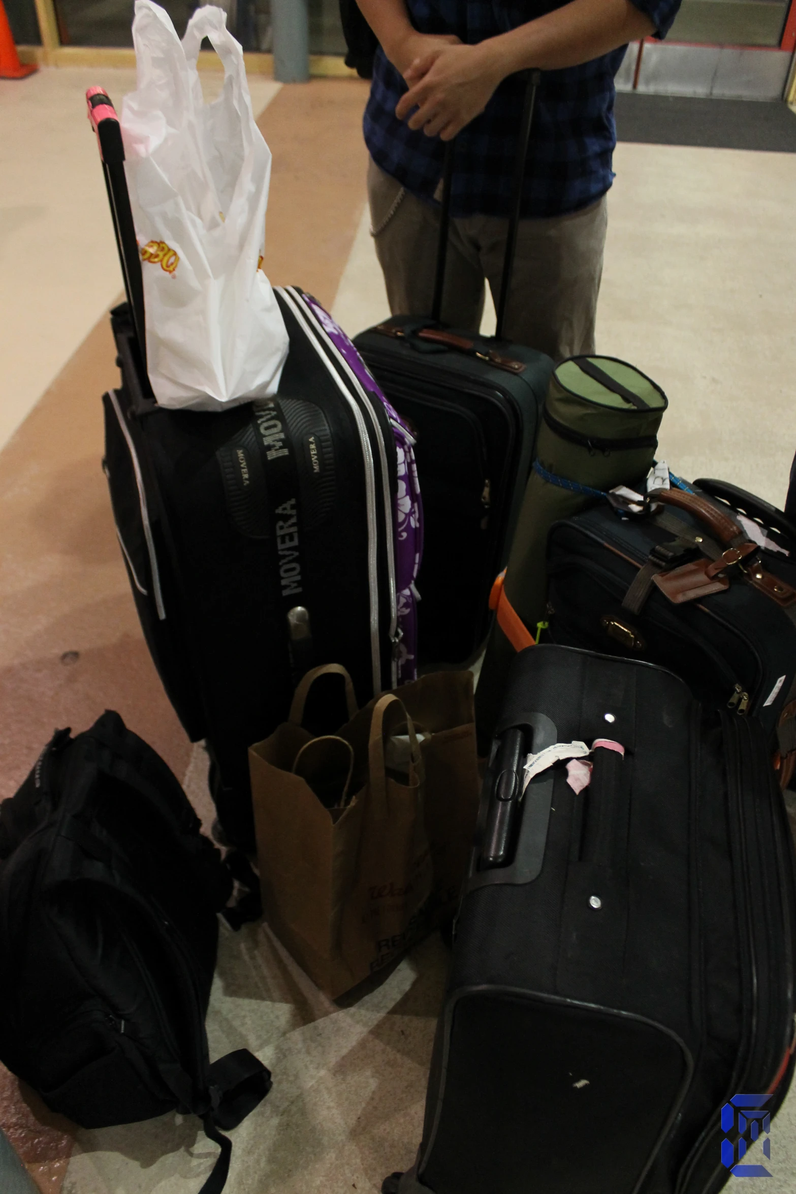 a man standing next to many bags of luggage