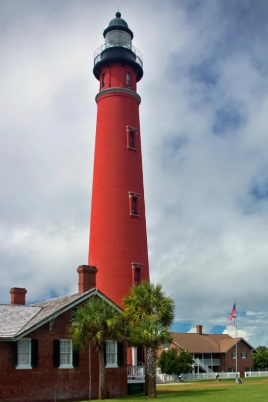 a tall red and white lighthouse with a flag on top