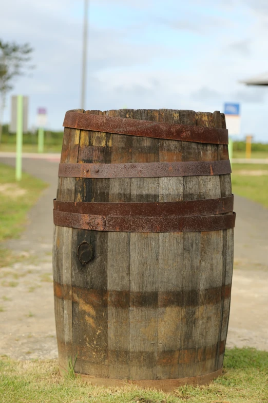 a very large wooden barrel sitting outside on grass