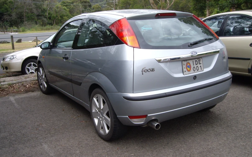 silver cars in parking lot with trees behind them