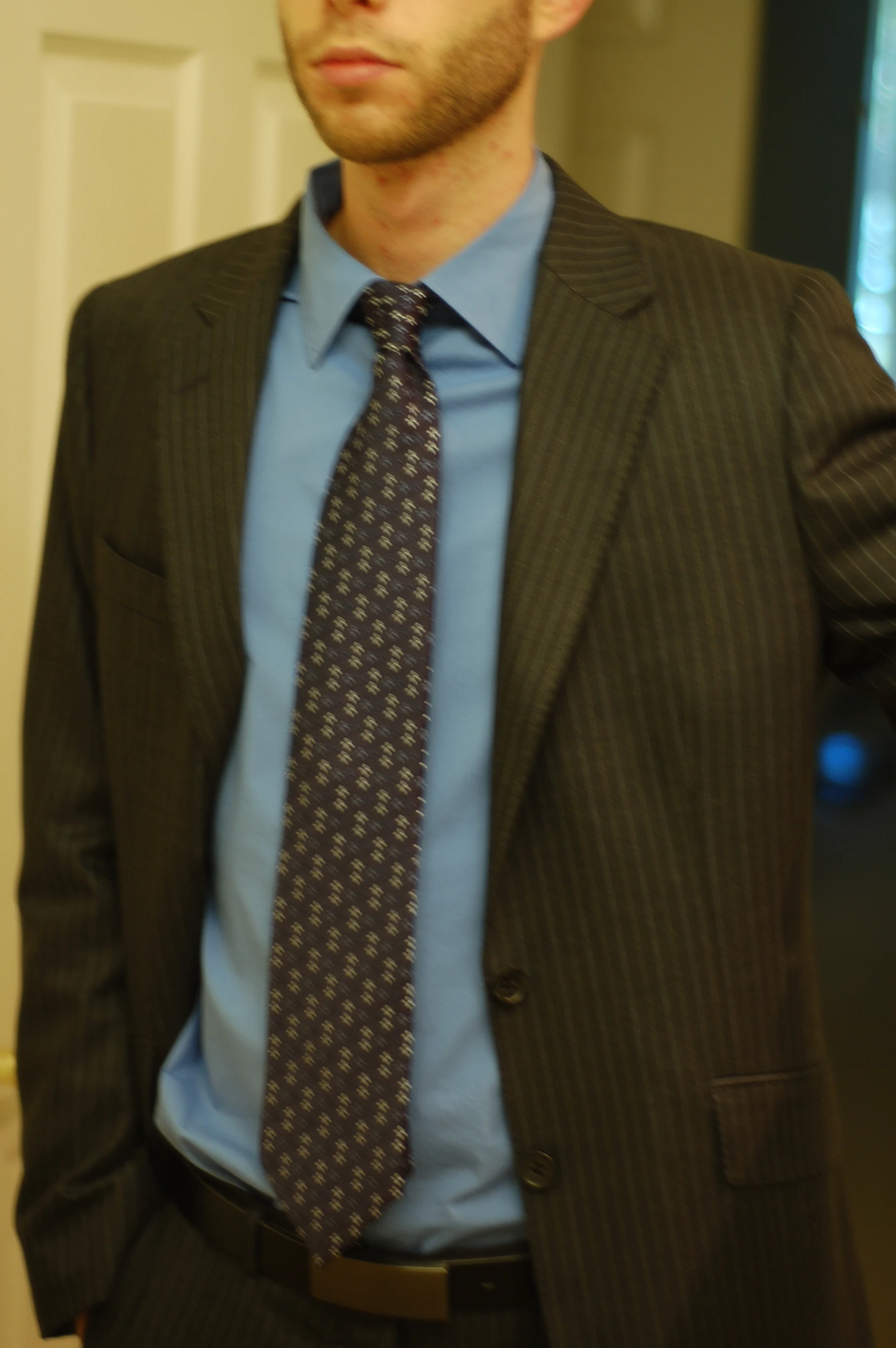 a man in a gray suit wearing a blue shirt