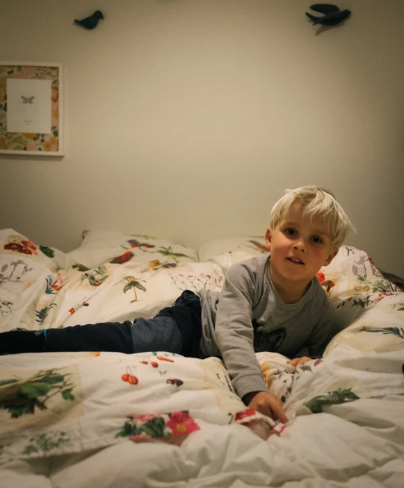 a small child lying on the bottom of a bed