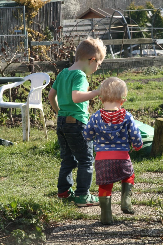 two little s in green shirts are in the grass