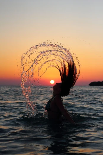 a woman in the water holding on to a circle of spiky hair