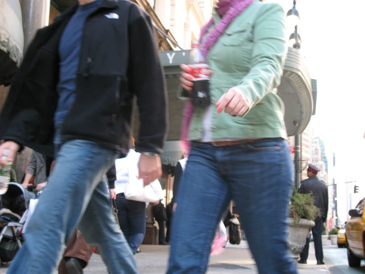 a close up of two people walking in the street