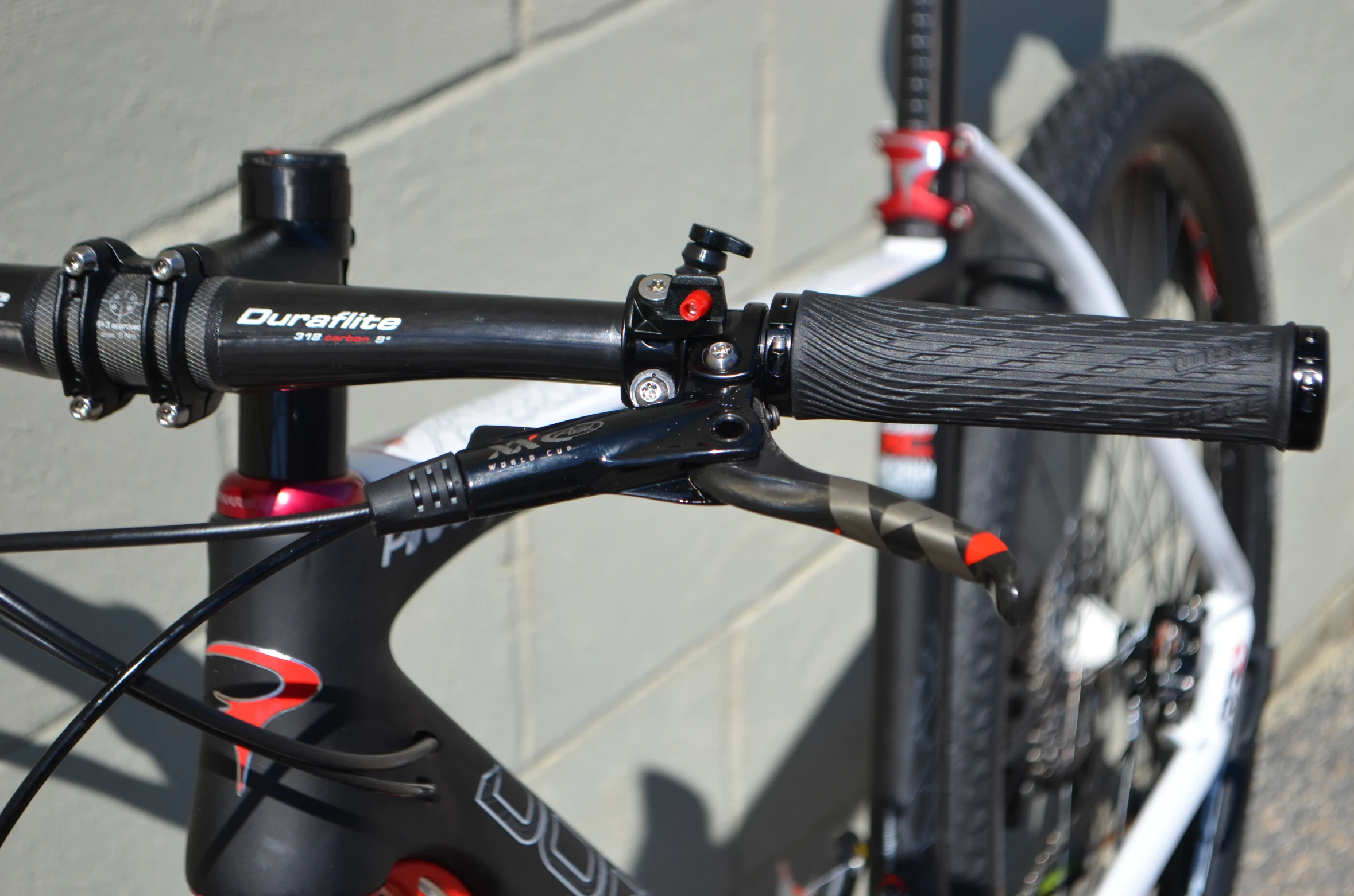 a bike is shown with red detailing near a brick wall