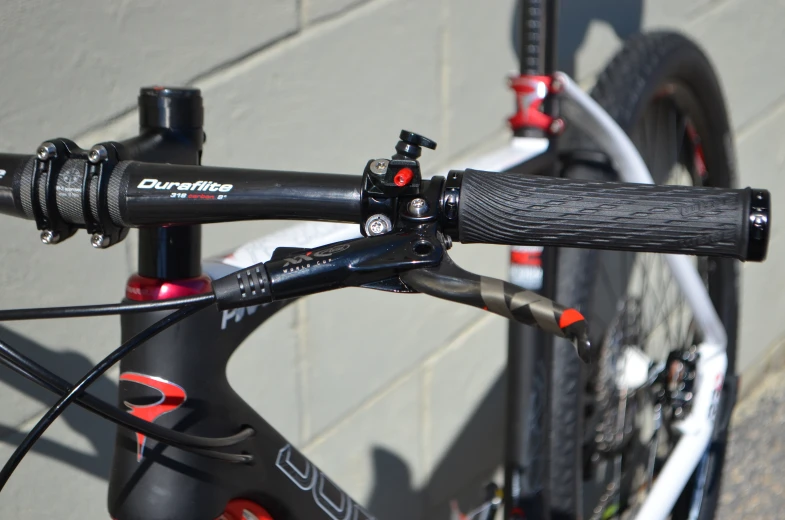 a bike is shown with red detailing near a brick wall