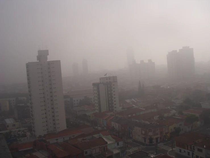 a hazy view from a building with roofs and tall buildings