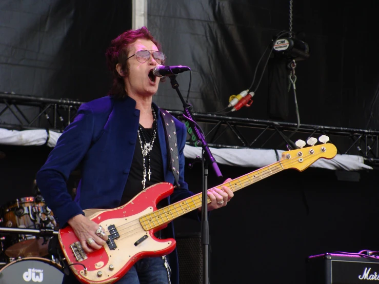 woman singing and playing an electric guitar at a concert