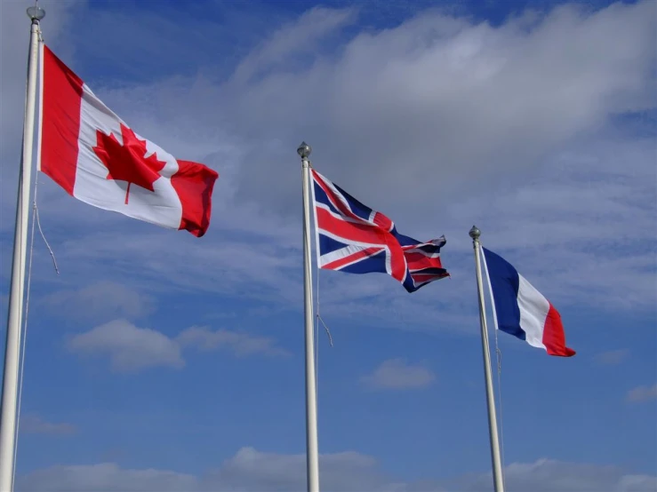 three british and canadian flags flying together