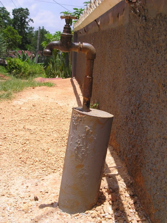 a water fountain, faucet and tank outside a home