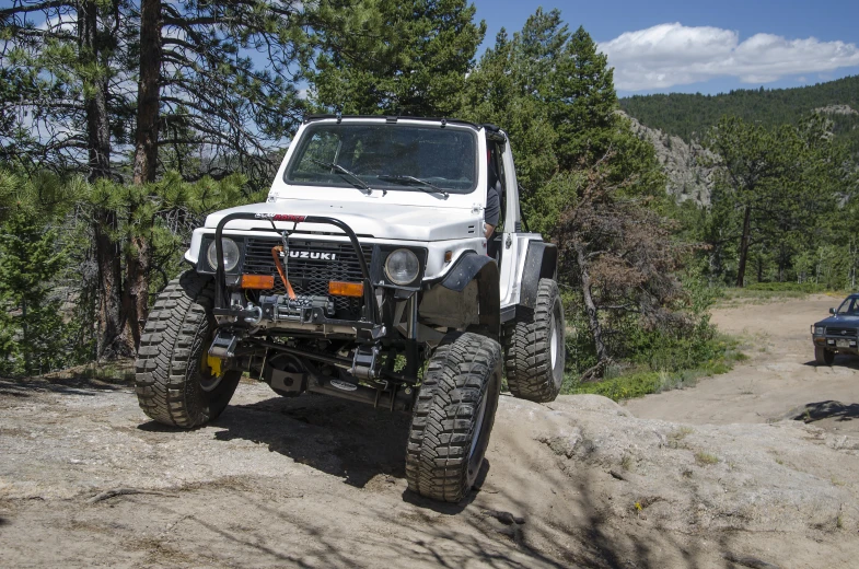 two men and one woman standing by their 4 - doored jeep