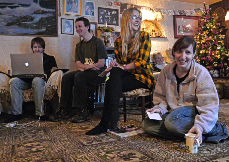 a group of people sitting around a living room on the floor