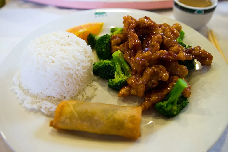 a white plate filled with broccoli, rice, and meat