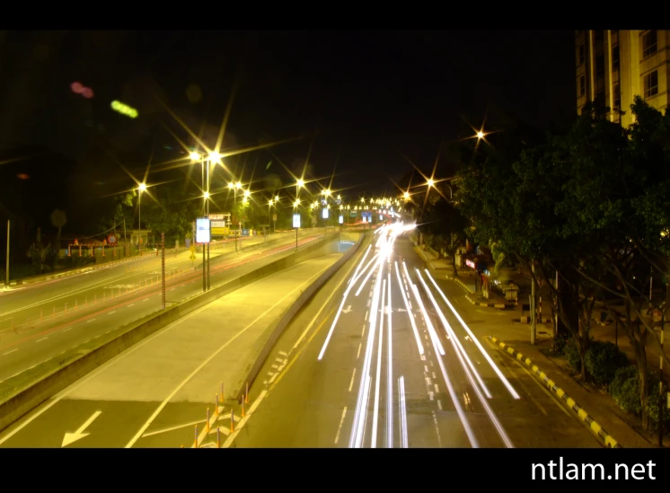 traffic lights on a highway and in the distance there is no one