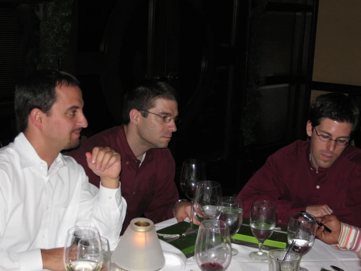 two men are sitting at the table with their drinks