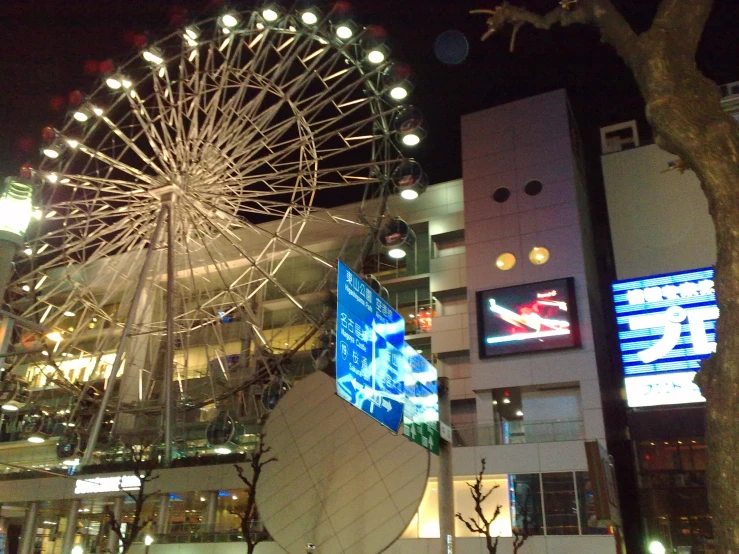 a huge wheel in front of a tall building