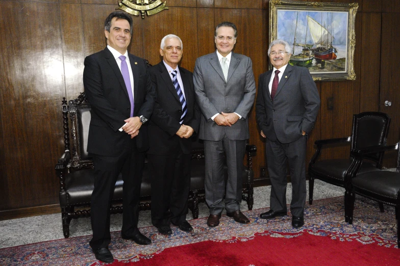 the four men are standing in the office