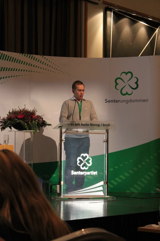 man talking on stage during conference at large event