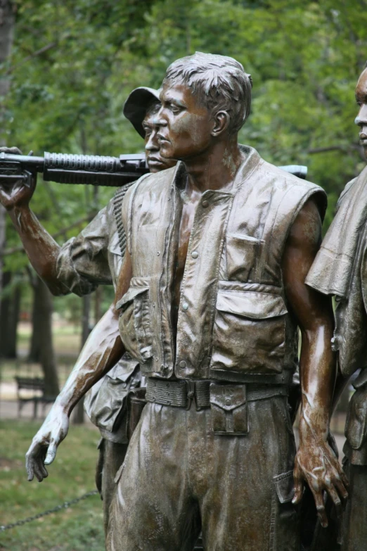 a man holding a gun to another statue in the park