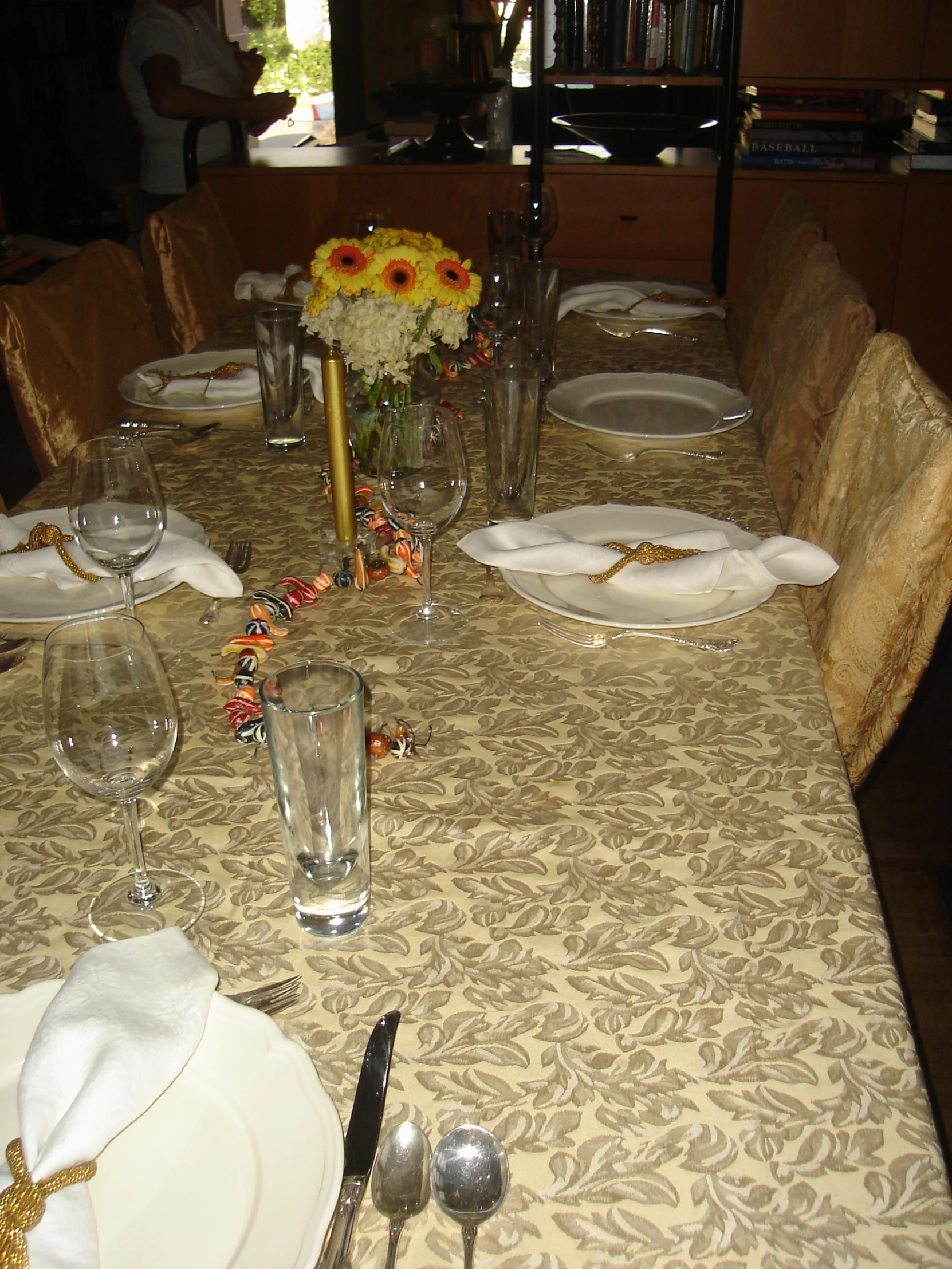 a dinning table with place settings, vases, silverware and flowers