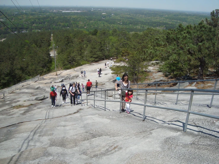 a large group of people on a slope near a fence