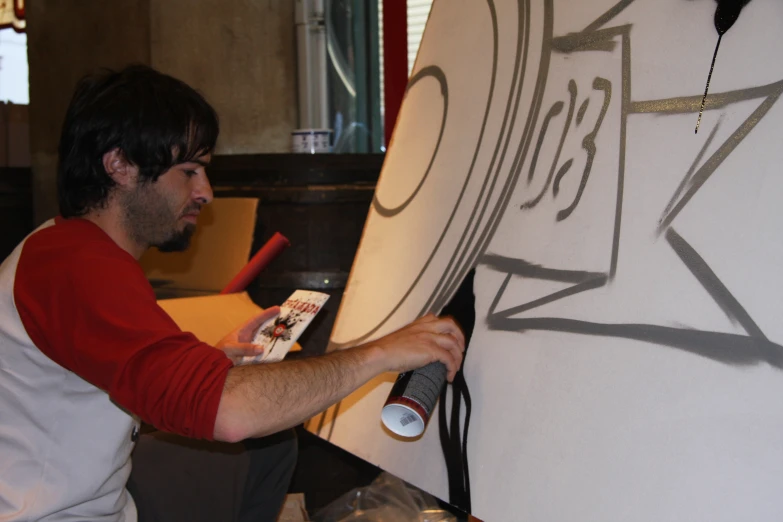 a man works on some artwork with a white board