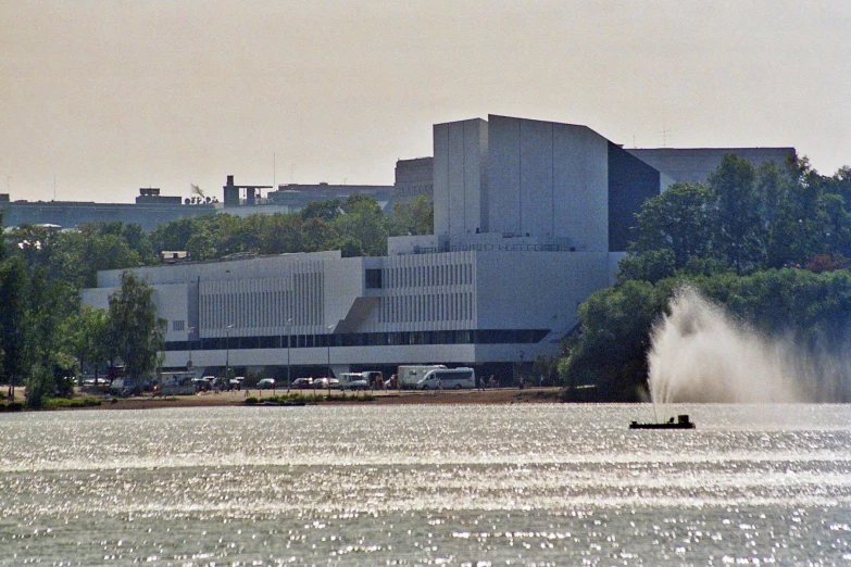 water spraying off a boat as the boat leaves behind the buildings