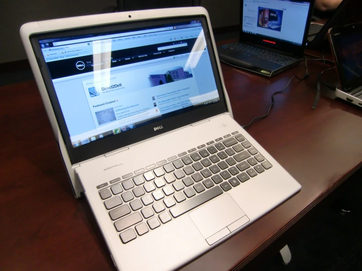 there is a lap top on a wooden desk