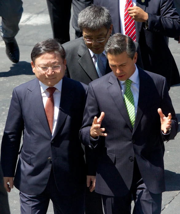 a group of men walking next to each other in suits