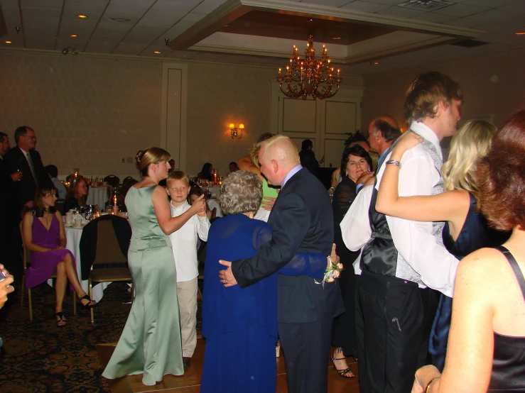 group of people in formal dress dances at a party