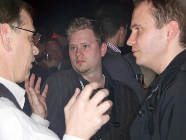 three men are sitting down together in the dark