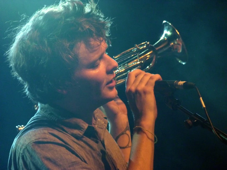 a man playing a trumpet while performing on stage