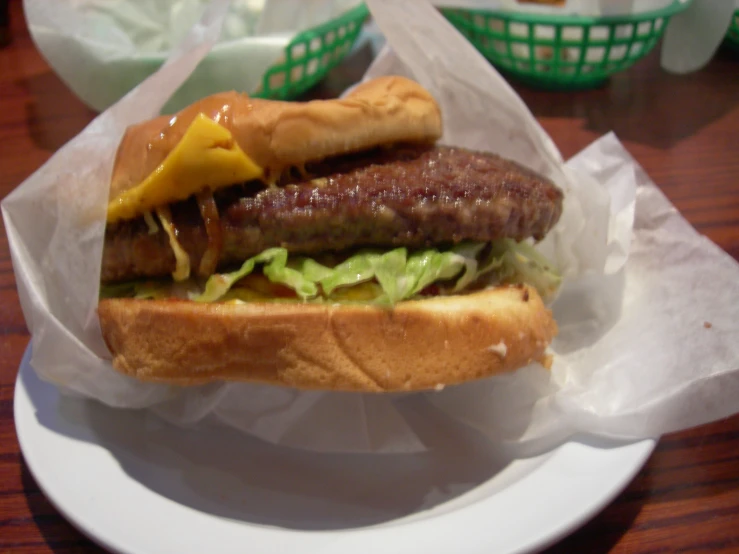 a grilled sausage sandwich with lettuce on a plate