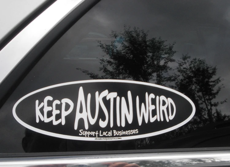 the sticker says keep austin weird on the back of the car