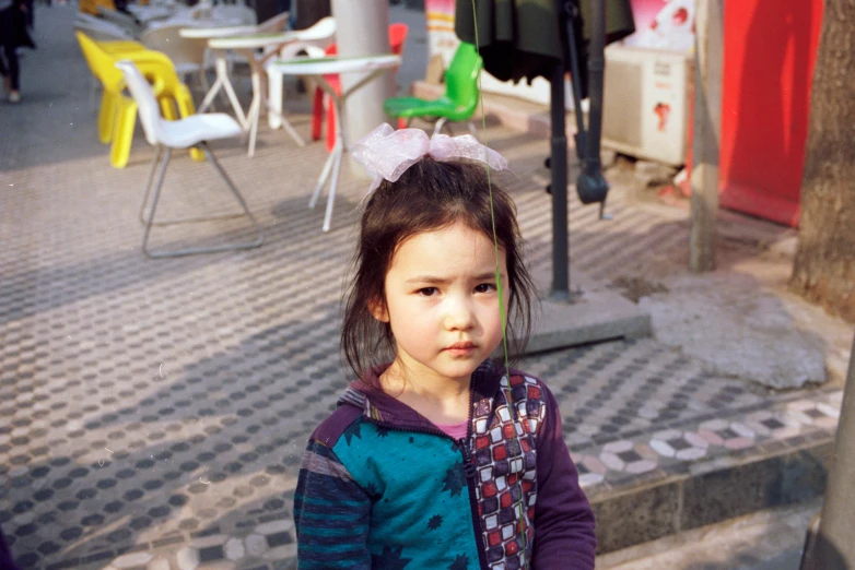 a little girl standing on the street corner