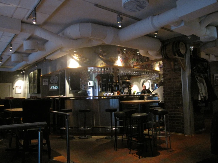 an empty bar with stools at the front