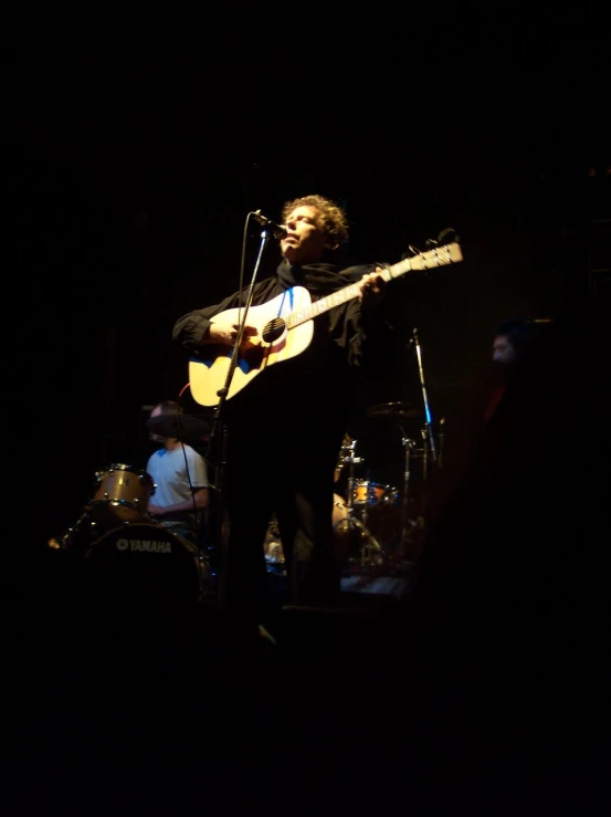 a man in a dark room playing guitar