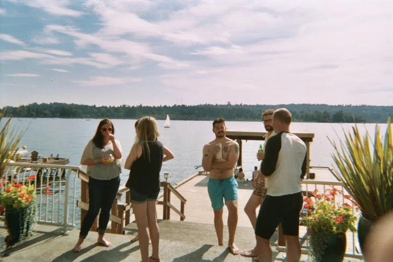 group of people standing on pier looking at the water