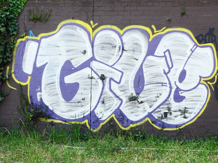 a brick wall is covered in purple graffiti