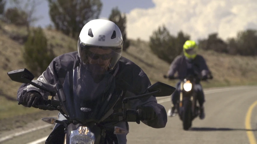 a couple of people that are riding motorcycles down the road