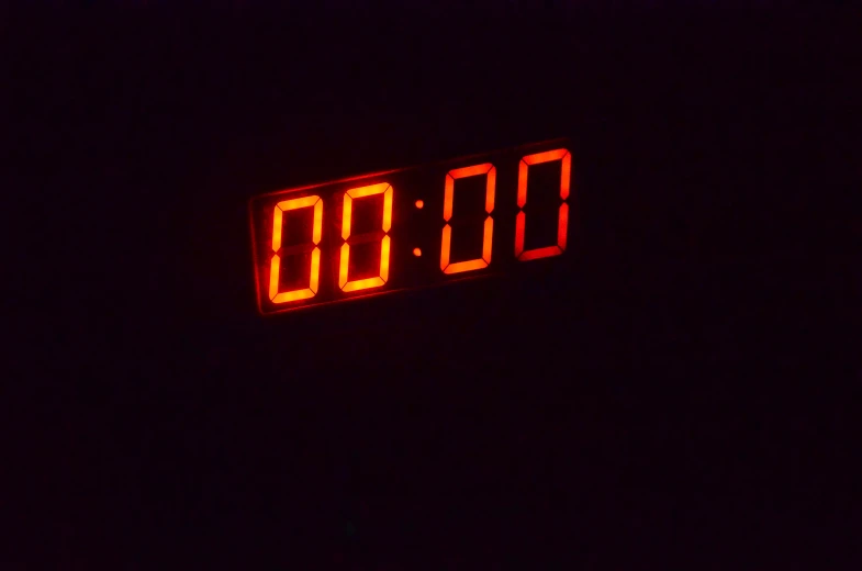 a clock sitting on top of a black wall