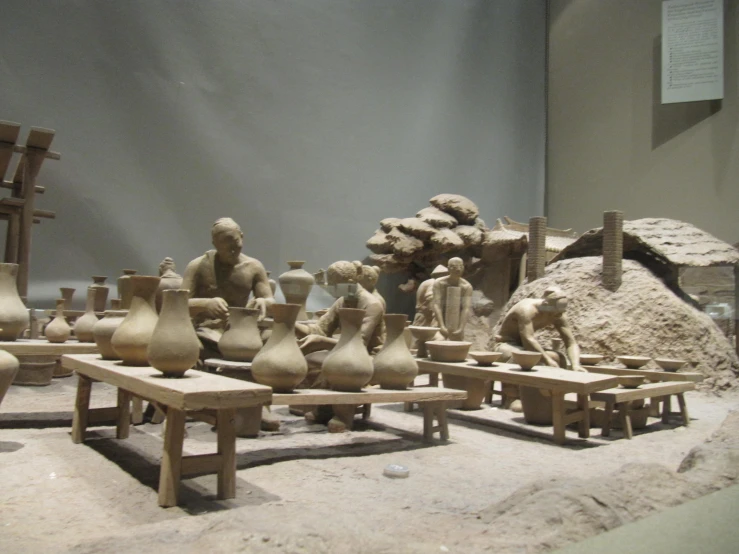 several statues sitting on benches near a building